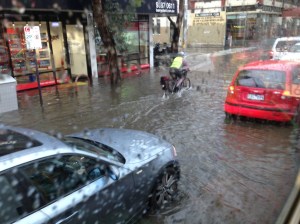 A cyclist pushes through floodwaters in Brunswick